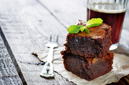 33573095 - brownie on a dark wood background. tinting. selective focus on mint