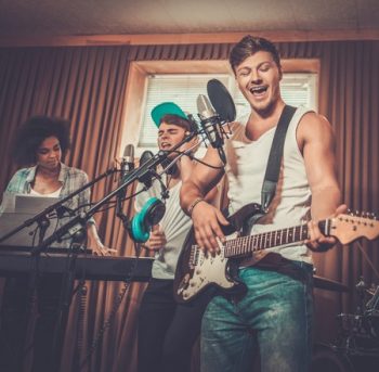 43588985 - multiracial music band performing in a recording studio