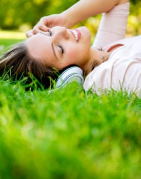 15391882 - woman listening to music with headphones at the park